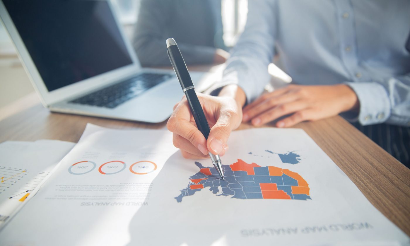 Hand of businesswoman pointing at USA map on paper